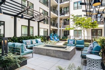 an outdoor lounge area with couches and chairs and a fountain